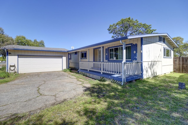 ranch-style house featuring covered porch, a garage, and a front lawn