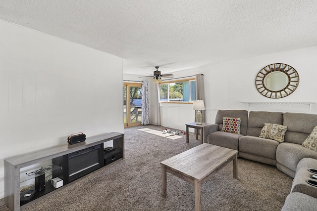 carpeted living room with ceiling fan and a textured ceiling