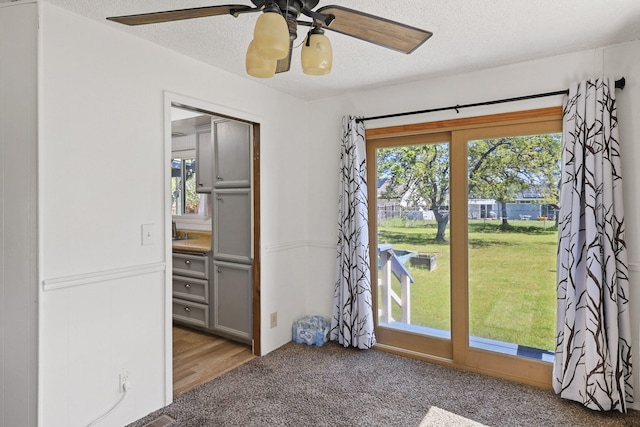 interior space with ceiling fan, a textured ceiling, and a closet