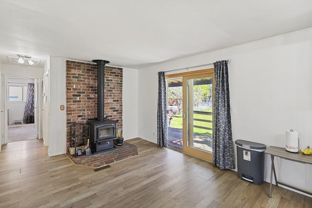 living room with light wood-type flooring and a wood stove