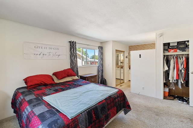 bedroom with a closet, light colored carpet, and a textured ceiling