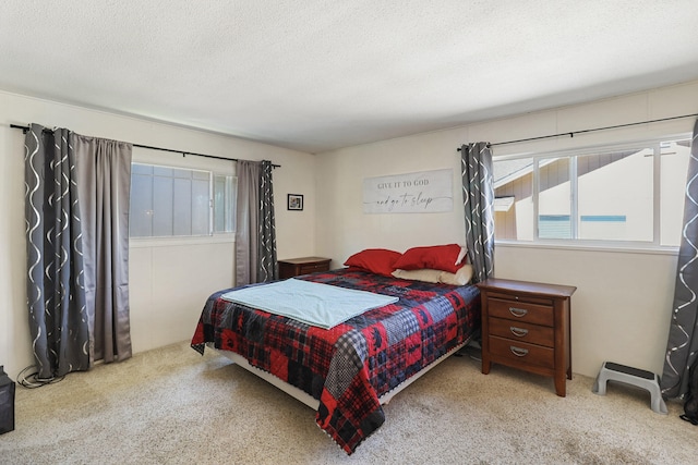 bedroom featuring light carpet and a textured ceiling