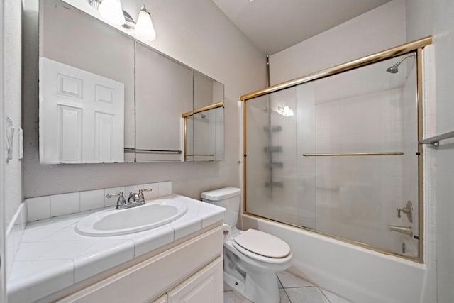 bathroom featuring toilet, tile patterned flooring, enclosed tub / shower combo, and vanity