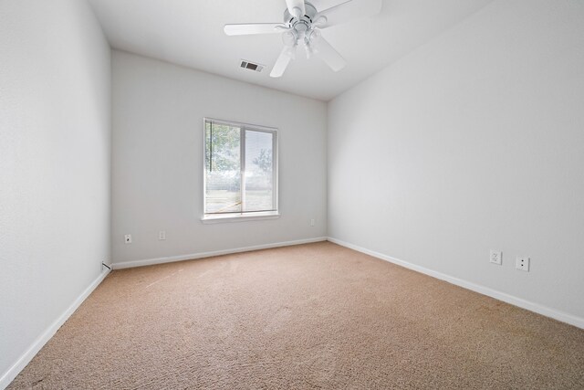 empty room with baseboards, a ceiling fan, visible vents, and light colored carpet