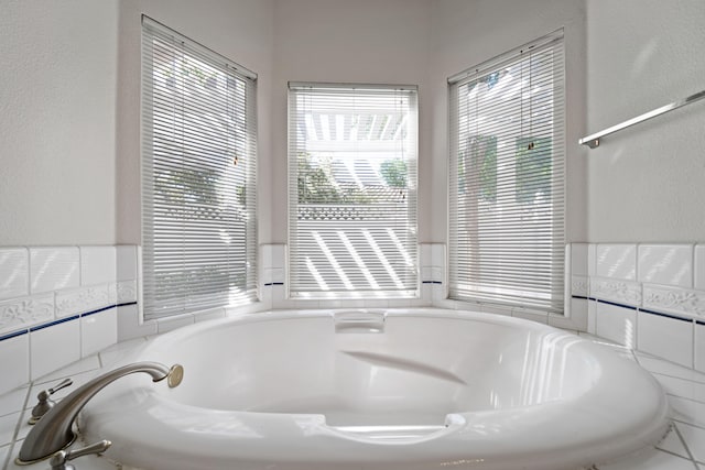 bathroom with a wealth of natural light and a relaxing tiled bath