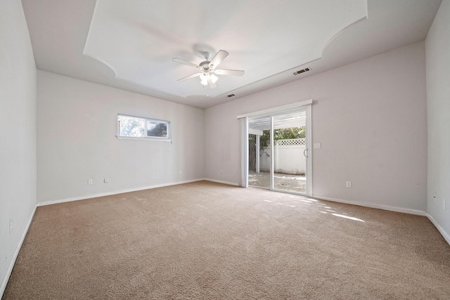 spare room featuring carpet floors, visible vents, ceiling fan, and baseboards