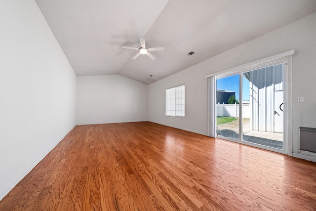 interior space featuring lofted ceiling, light wood finished floors, ceiling fan, and visible vents