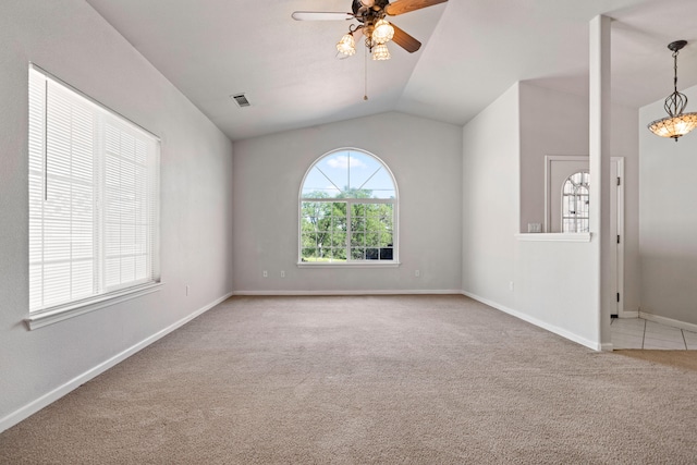 carpeted empty room with a ceiling fan, visible vents, vaulted ceiling, and baseboards