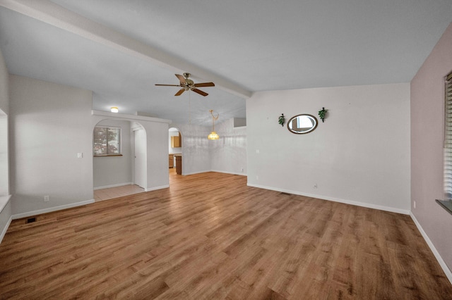 unfurnished room featuring vaulted ceiling with beams, wood-type flooring, and ceiling fan