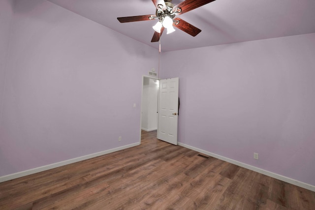 empty room with ceiling fan, hardwood / wood-style flooring, and a high ceiling