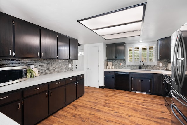 kitchen featuring dishwasher, light hardwood / wood-style floors, and decorative backsplash