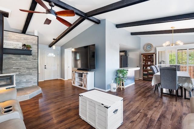 living room with dark wood-type flooring, ceiling fan with notable chandelier, vaulted ceiling with beams, and a wood stove