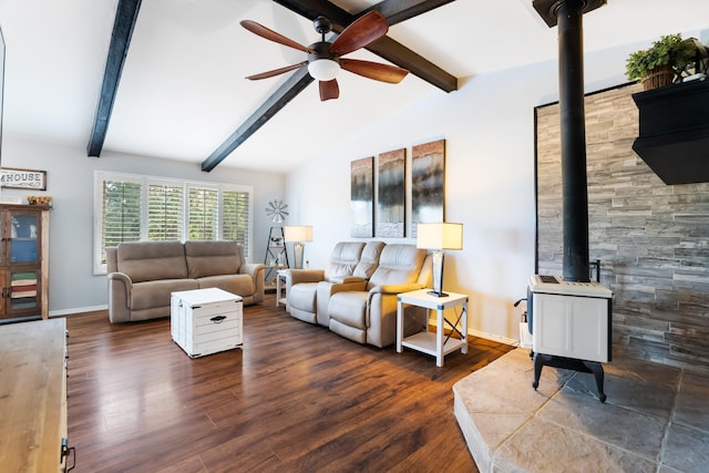 living room with ceiling fan, a wood stove, dark hardwood / wood-style floors, and vaulted ceiling with beams