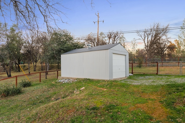 outdoor structure at dusk featuring a garage and a yard