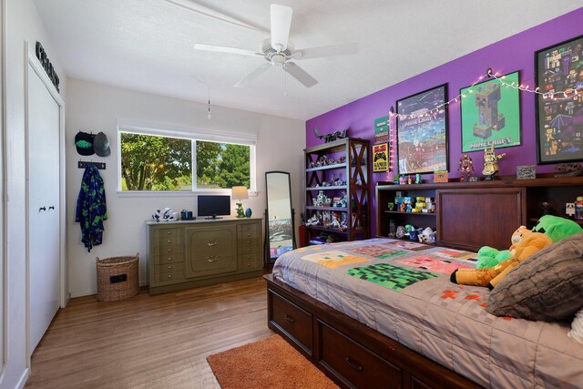 bedroom with ceiling fan, light hardwood / wood-style flooring, and a closet