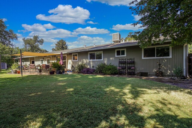 rear view of property featuring a yard