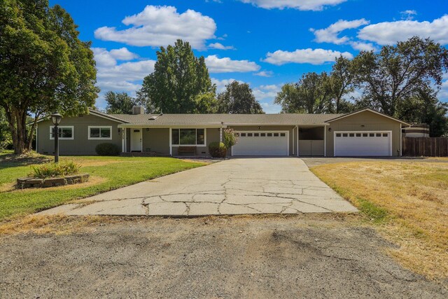 single story home featuring a garage and a front lawn