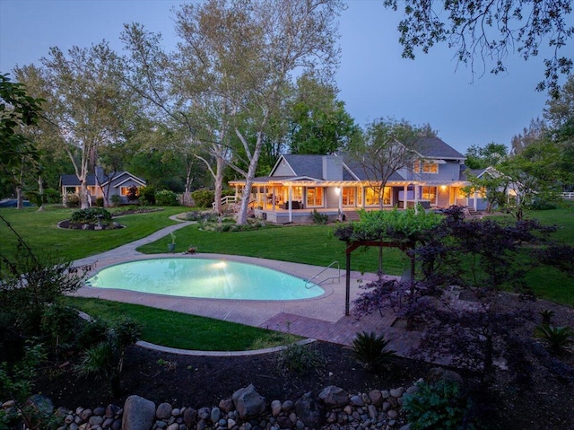 pool at dusk with a yard