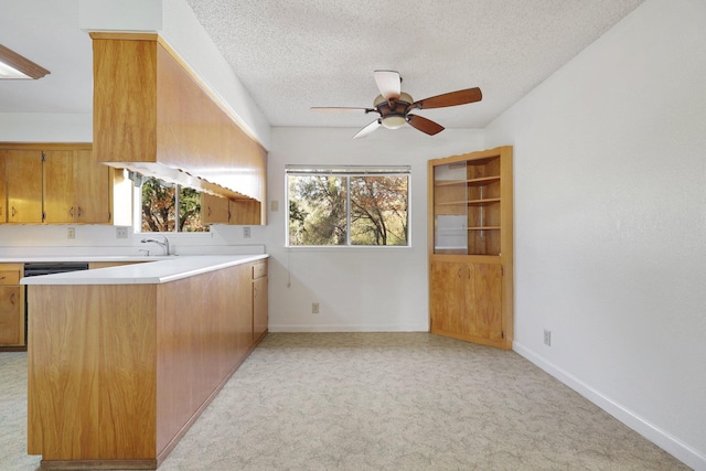 kitchen with kitchen peninsula, a textured ceiling, light colored carpet, and ceiling fan