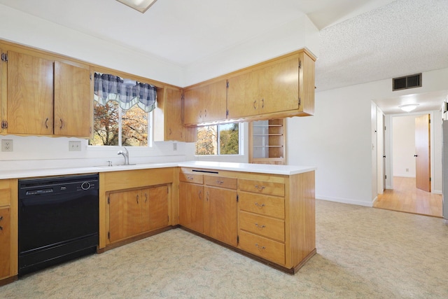 kitchen with dishwasher, sink, a textured ceiling, light colored carpet, and kitchen peninsula