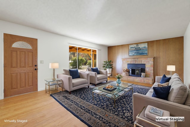 living room with a wood stove, wood walls, and hardwood / wood-style flooring