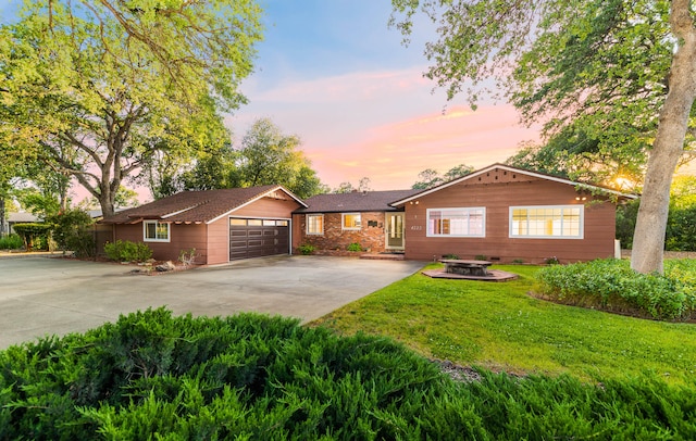 ranch-style home with a garage and a lawn