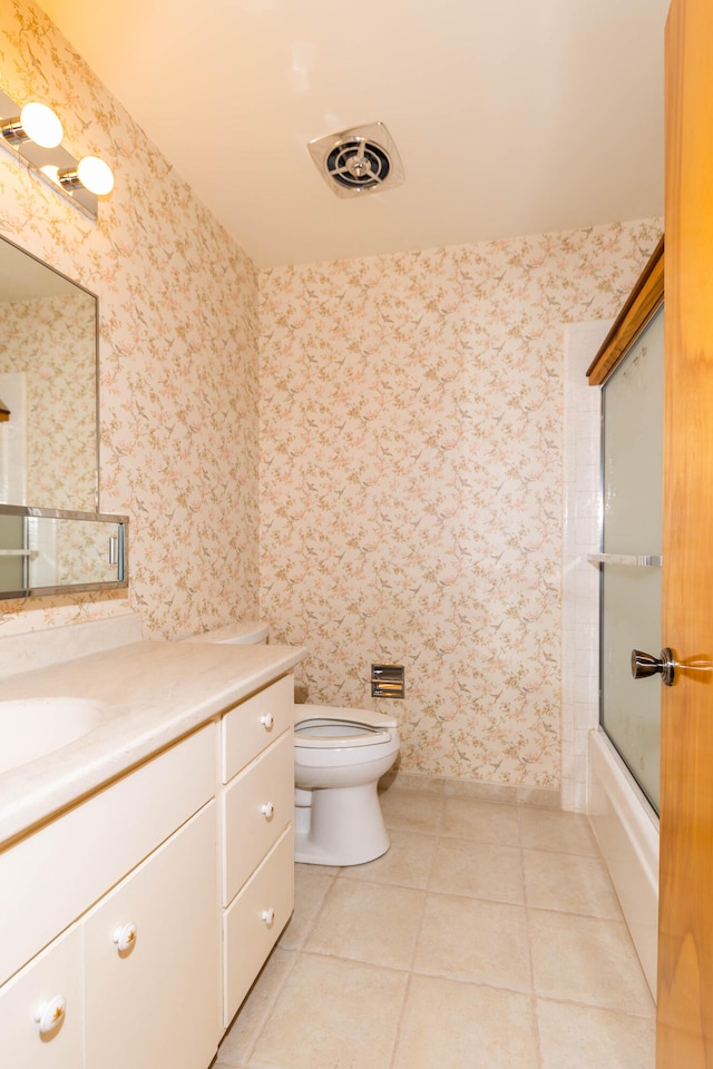 full bathroom featuring vanity, toilet, tile floors, and shower / bath combination with glass door