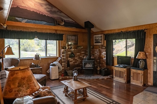 living room featuring hardwood / wood-style floors, lofted ceiling, and a wood stove