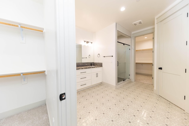 bathroom with walk in shower, vanity, and tile floors