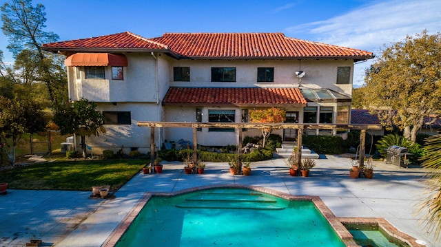 rear view of house featuring a lawn and a patio