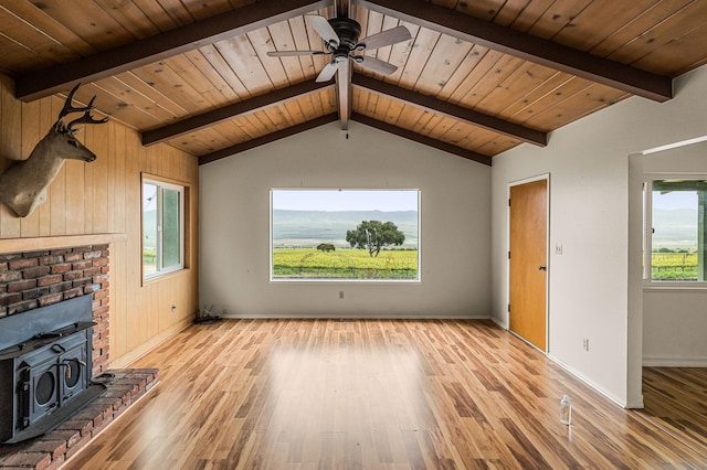 unfurnished living room with lofted ceiling with beams, a fireplace, and wood ceiling