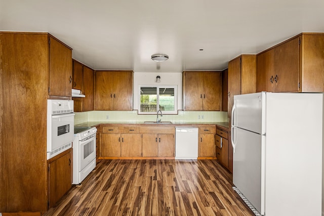 kitchen with sink, ventilation hood, white appliances, and dark hardwood / wood-style floors