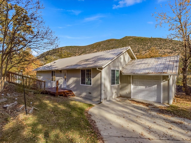 ranch-style house featuring a deck with mountain view and a garage