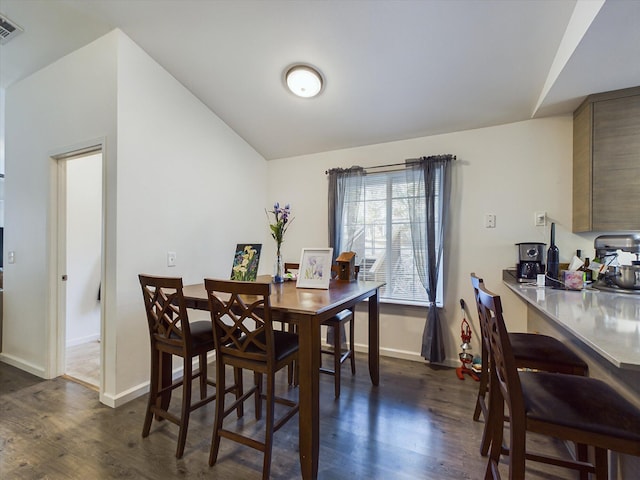 dining space with dark wood-type flooring and lofted ceiling