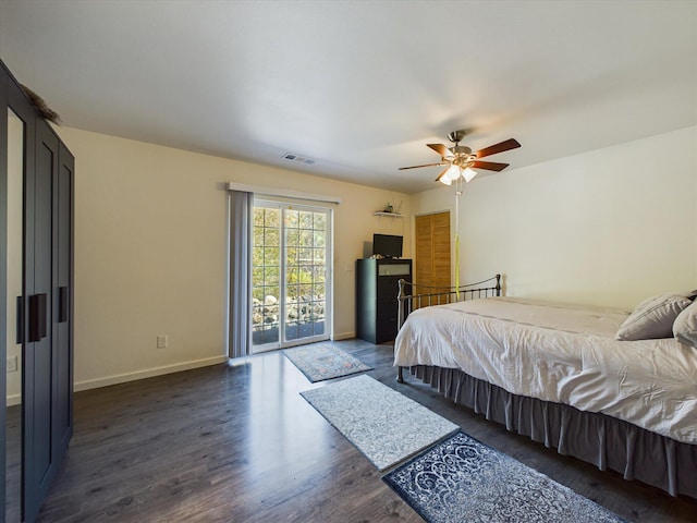 bedroom with dark hardwood / wood-style floors, ceiling fan, and access to exterior