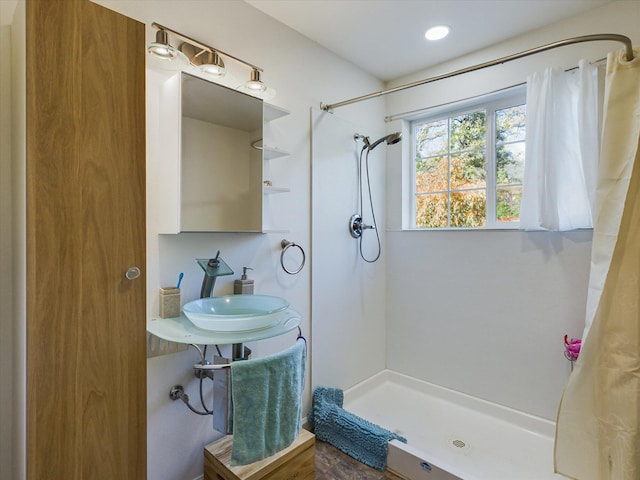 bathroom featuring walk in shower and sink