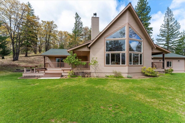 rear view of property featuring a wooden deck and a yard