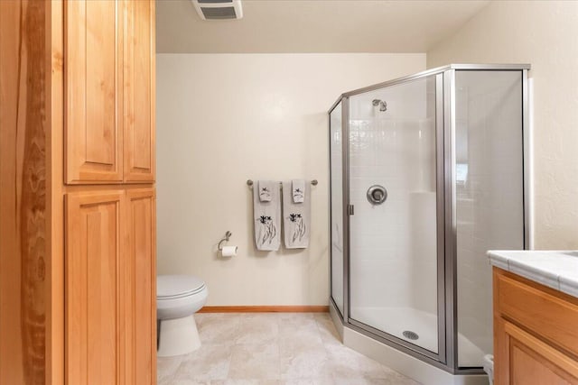 bathroom featuring a shower with door, tile flooring, toilet, and vanity