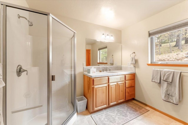 bathroom featuring plenty of natural light, tile flooring, vanity with extensive cabinet space, and a shower with shower door