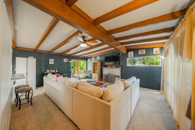 carpeted living room with ceiling fan, a healthy amount of sunlight, wooden walls, and a brick fireplace