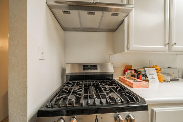 kitchen featuring white cabinets, gas stove, and exhaust hood