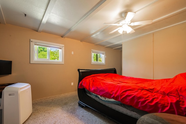 bedroom featuring carpet, ceiling fan, and beamed ceiling