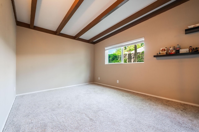 carpeted spare room featuring vaulted ceiling with beams