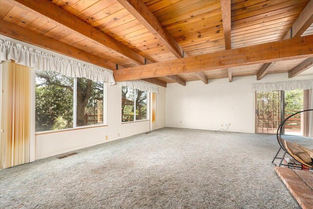 interior space featuring carpet flooring, a healthy amount of sunlight, beam ceiling, and wooden ceiling