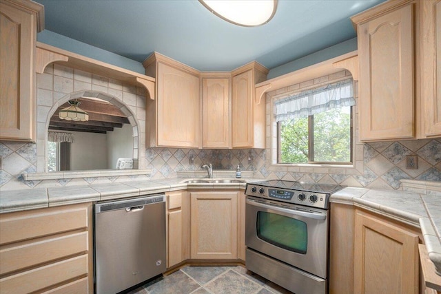 kitchen with decorative backsplash, appliances with stainless steel finishes, tile counters, light tile patterned flooring, and light brown cabinets