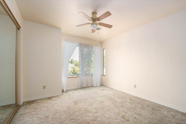 carpeted empty room with ceiling fan