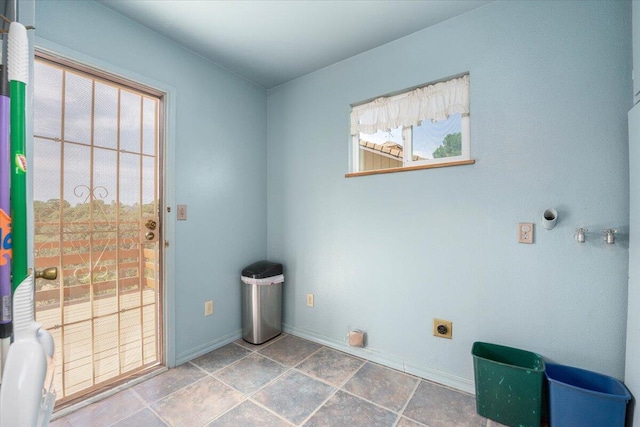 clothes washing area featuring tile patterned floors, hookup for an electric dryer, and a healthy amount of sunlight