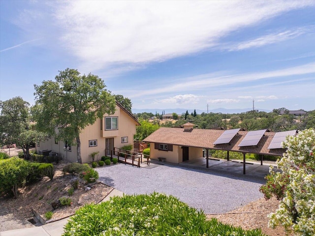 exterior space featuring solar panels and a carport