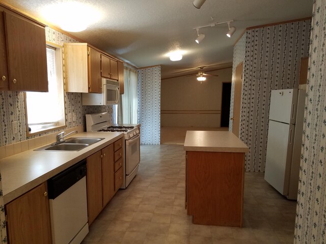 kitchen with ceiling fan, rail lighting, sink, white appliances, and light tile floors