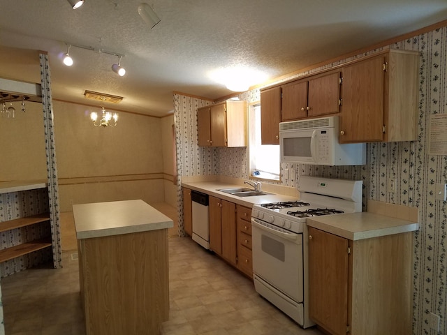kitchen with sink, white appliances, decorative light fixtures, and a textured ceiling